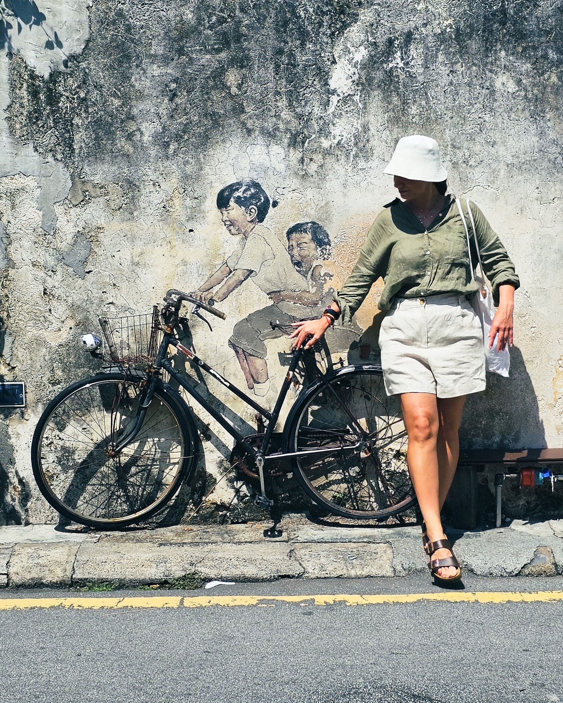 Kids on a Bicycle mural by Ernest Zacharevic on Lebuh Armenian, two painted children riding a real bicycle prop